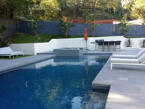 Contemporary Pool with white concrete retaining wall