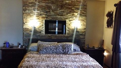 Transitional Bedroom with built in fireplace above headboard