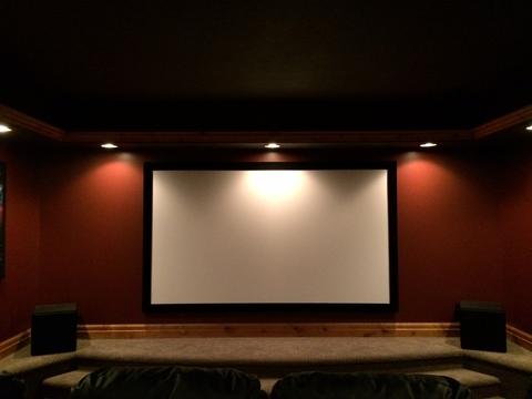 Traditional Home Theater with acoustically transparent projector screen with a ported subwoofer on each