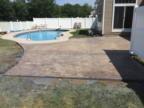 Transitional Pool with stamped and tinted concrete patio