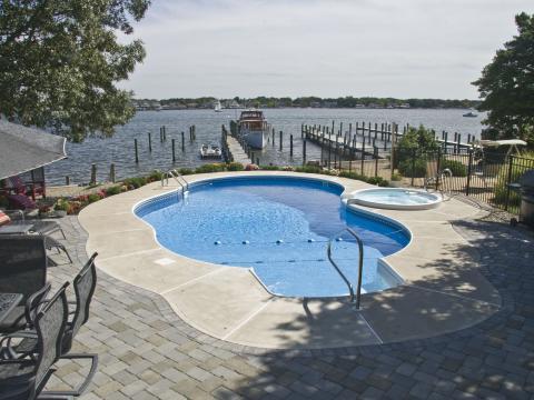 Traditional Pool with poured concrete pool deck
