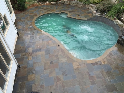 Traditional Pool with dry stacked stone retaining wall