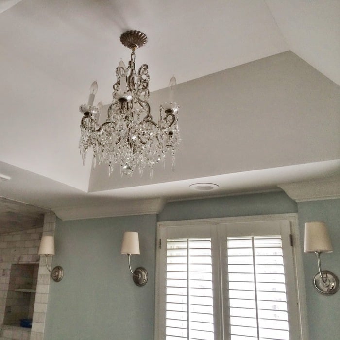 Transitional living room with crystal chandelier and light blue wall paint