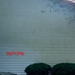 Before photo of a 2 story home covered in algae.