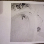 Picture of bathtub of grime and stain from hard wa