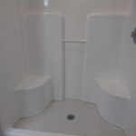 fiberglass shower with stone accents in the bottom