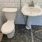Toilet and vanity with floor drain