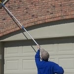 De-webbing the eves of a home.