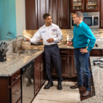 Plumber in Kitchen with Customer