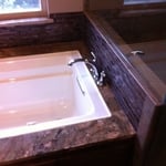 new tub with tile and granite surround