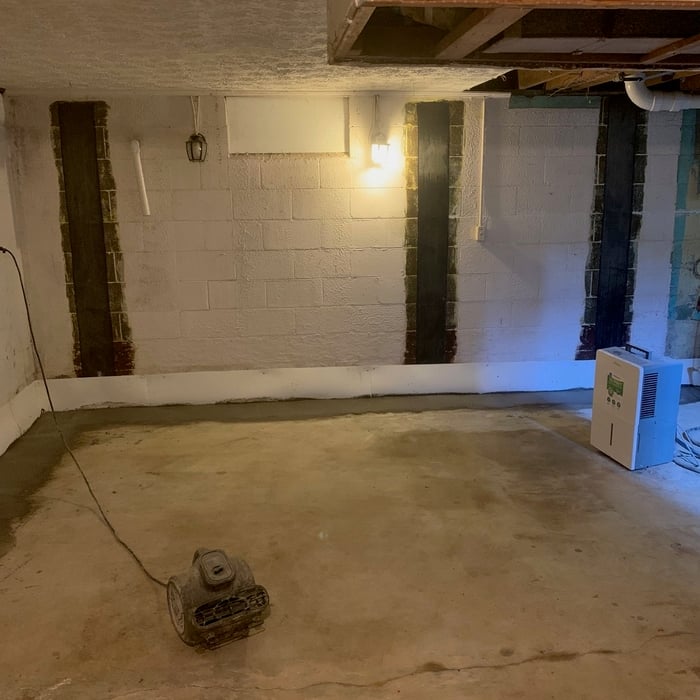 Finished waterproofing system allowing water to drain from blocks into a dug trench with corrugated pipe cover by river rock flowing into the pit which is then pumped outside through the discharge line. Carbon fiber walls straps are also put in to help support the main foundation keeping the walls from bowing in.