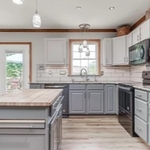 Upgraded French door, new LVT flooring, freshly painted 'tuxedo' cabinets and island, upgraded granite countertops and window sill, new sink and faucet, new stained trim, upgraded overhead, task, and pendent lighting, new appliances, and new under cabinet LED lighting.