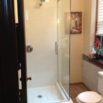 Frameless shower enclosure with header