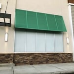 Exterior view of a commercial plaza retail space with frosted window film installed by Precision Safety Films, showcasing enhanced privacy and a sleek, modern appearance.