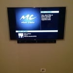 flat screen hung on the wall, concealed wires and sound bar.
