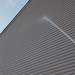 Rinsing Vinyl Siding after soap application.