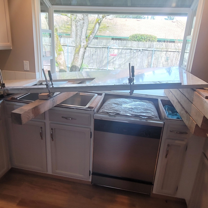 Getting the sink run into place using pieces of wood to keep it at an angle.