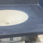 Color evening prima by Corian. Single sink vanity with integrated sink, cove backsplash which is backsplash that is integrated and curved with the countertop so that it’s all one piece no gaps no fills all is one piece before the install