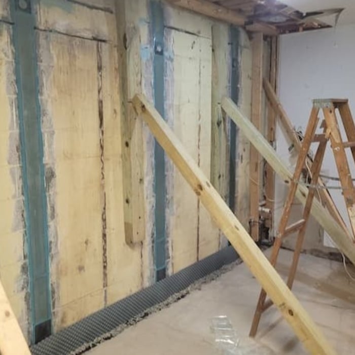Installation of carbon fiber straps and epoxy to lock the foundation wall back into the proper position.