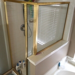 This is Before with gold framed glass, difficult to clean moldy grout tile, and a stained shower pan. Somewhere a leak had developed dripping to the ceiling below.