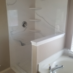 Frameless glass will be installed in a week or two. This has a custom solid surface stone shower floor with a 10 year warranty, a textured nonslip surface, sloped to the drain with smooth drain canals climbing towards the drain to assure maximum drainage. Above are matching stone walls in #68.