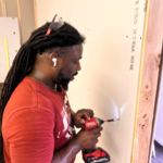 Picture of myself installing some drywall.