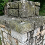 Stone pillar with mold and moss buildup.