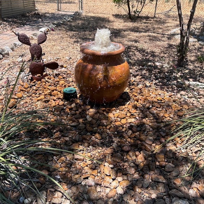 Fountain fed by water pump, with water basin to allow spill over.