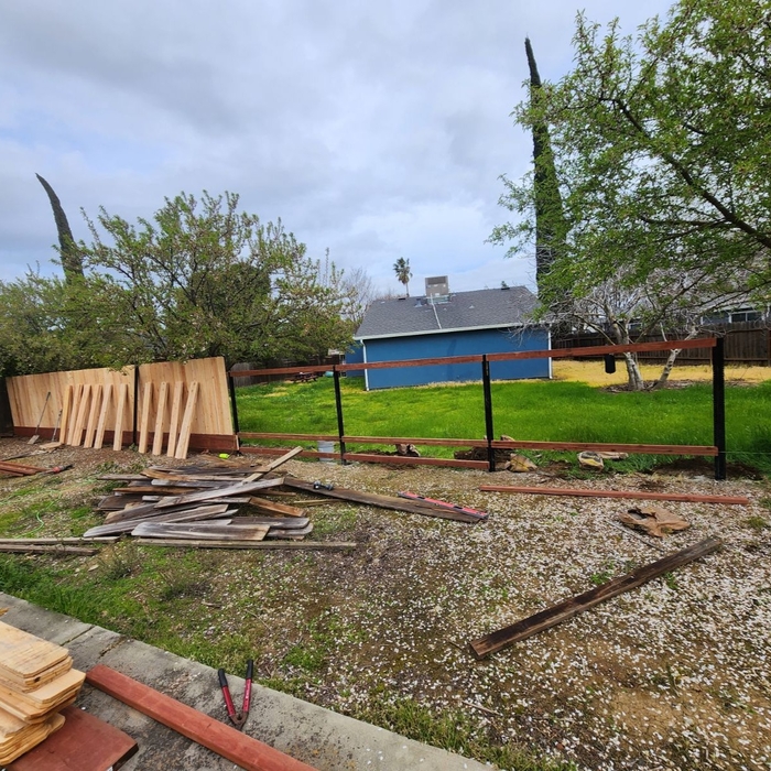 Knocked down the old fence. Began placing new posts and installing the fence.