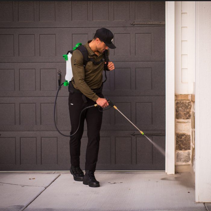 Technician spraying the base of a home.