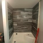 Shower base and tile. Custom built bump out wall for plumbing.