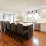 This large kitchen in Plymouth Meeting was remodeled to better fit the homeowners’ busy family life. A wall was removed between the family room and kitchen to open up the space, and custom cabinets surrounding an over-sized island make for the perfect gathering spot. A spacious pantry, mail center, and wall chalkboard to keep track of the kids’ schedules all help support a busy family lifestyle. The transitional style finishes include unique sconces above the large sink, navy blue island ca