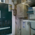 A tankless water heater installed in a garage.