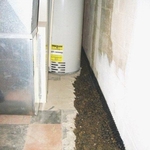 The 4 inch perforated pipe has been covered with 2B washed gravel. The miradrain (black waffle-like border) along the wall allows the bleeder holes to remain open when the floor is replaced. It also ensures that the water will pass over the footer as it feeds into the 4 inch perforated pipe along the footer. In this case we were able to work behind the furnace and hot water tank without removing them.