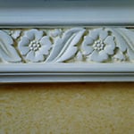 A detail of the crown moulding that caps the rag application surface. Note the handling of the background in the moulding relief.