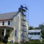 Using pipe staging to rebuild a chimney crown.