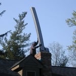 Relining a fireplace flue with insulated stainless steel.
