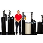 Our owner, David Brewster, standing next to a few options for whole-home water filtration. The size and caliber of the equipment is dependent on the house size and how many people use the water.