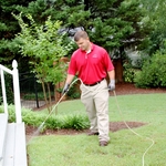 An APC Technician Applies a Liquid Barrier Around the Home