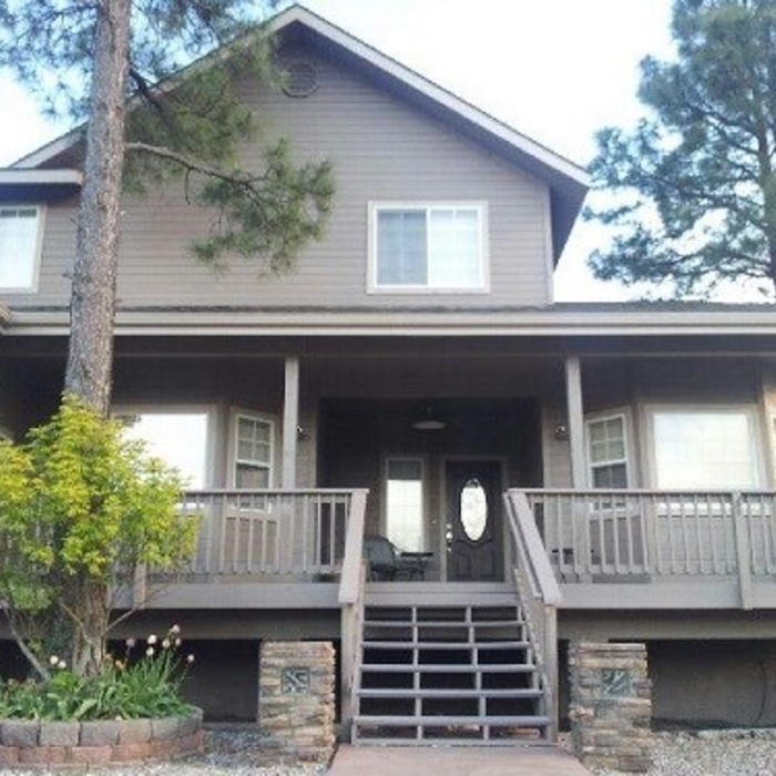 This house, with almost a ranch style feel, doesn't give off too much by using a minimalist color scheme. This appeals to homeowners who want to let mother nature shine through in the landscaping. You will note the dark wood door, however, centers the eye and provides a warm entry into the home.