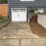 Existing driveway, right side was dug up and leveled for an extension. Right side retaining wall was previously poured and installed by our crew before this picture was taken.