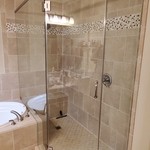 Frameless shower enclosure using brushed nickel color hardware.