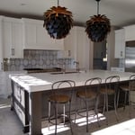 Empire Painting transformed this spacious kitchen space featuring white kitchen cabinets with contrasting black cabinet hardware, a black kitchen island, quirky lighting fixtures, and plenty of windows to provide light.
Eat-in kitchen - large transitional single-wall linoleum floor and beige floor eat-in kitchen idea in Milwaukee with a double-bowl sink, recessed-panel cabinets, white cabinets, marble countertops, gray backsplash, marble backsplash, stainless steel appliances, an island and wh