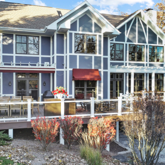 This beautiful coastal Nashotah home features Sherwin Williams' color of the year from 2020 Naval SW 6244. This shade is a rich navy that creates a calm and grounding environment infused with quiet confidence. White trim throughout provides the right amount of contrast.
Example of a huge beach style blue two-story stucco and board and batten exterior home design in Milwaukee with a shingle roof and a gray roof