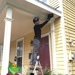 Andrew dusting the carpenter bee damage before hanging two carpenter bee traps.
