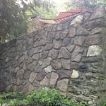 Deteriorated mortar joints on outside retaining wall.