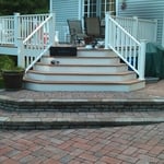 Step and landing area created off of deck using Acadia Cumberland blend pavers and granite color wall blocks with caps..