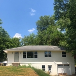 Home exterior after rebuilding eaves, installing all new doors and windows and priming and painting the restored red wood siding