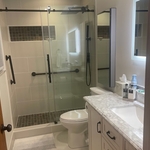 Custom shower with niche, new vanity floor tile, drywall, and toilet.