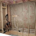 This is a laundry room was converted into a walk in shower travertine tile, Glass panels, shower ahead drop from ceiling.